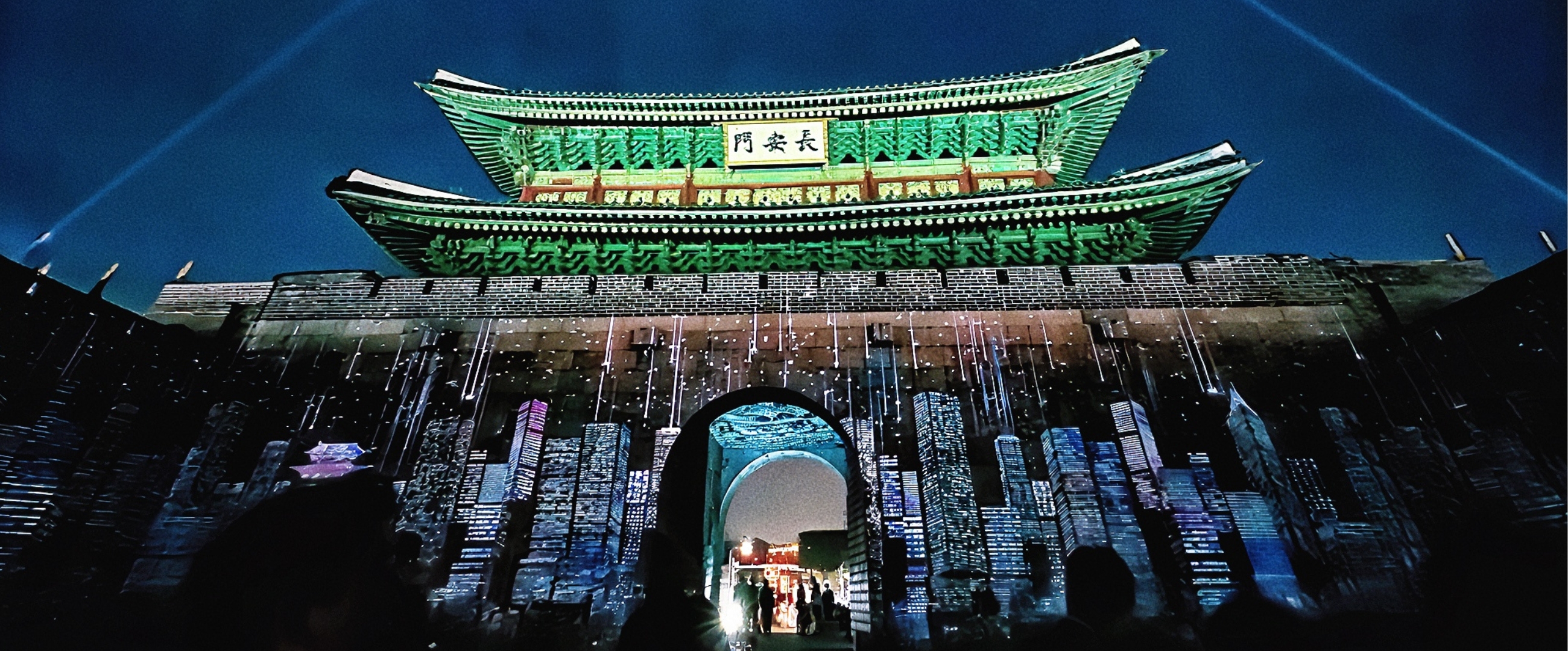 수원 화성 성곽을 스크린 삼아 펼쳐지는 화려한 미디어 아트 쇼. 다채로운 색의 조명과 패턴이 성벽을 가득 채우고 있다.
