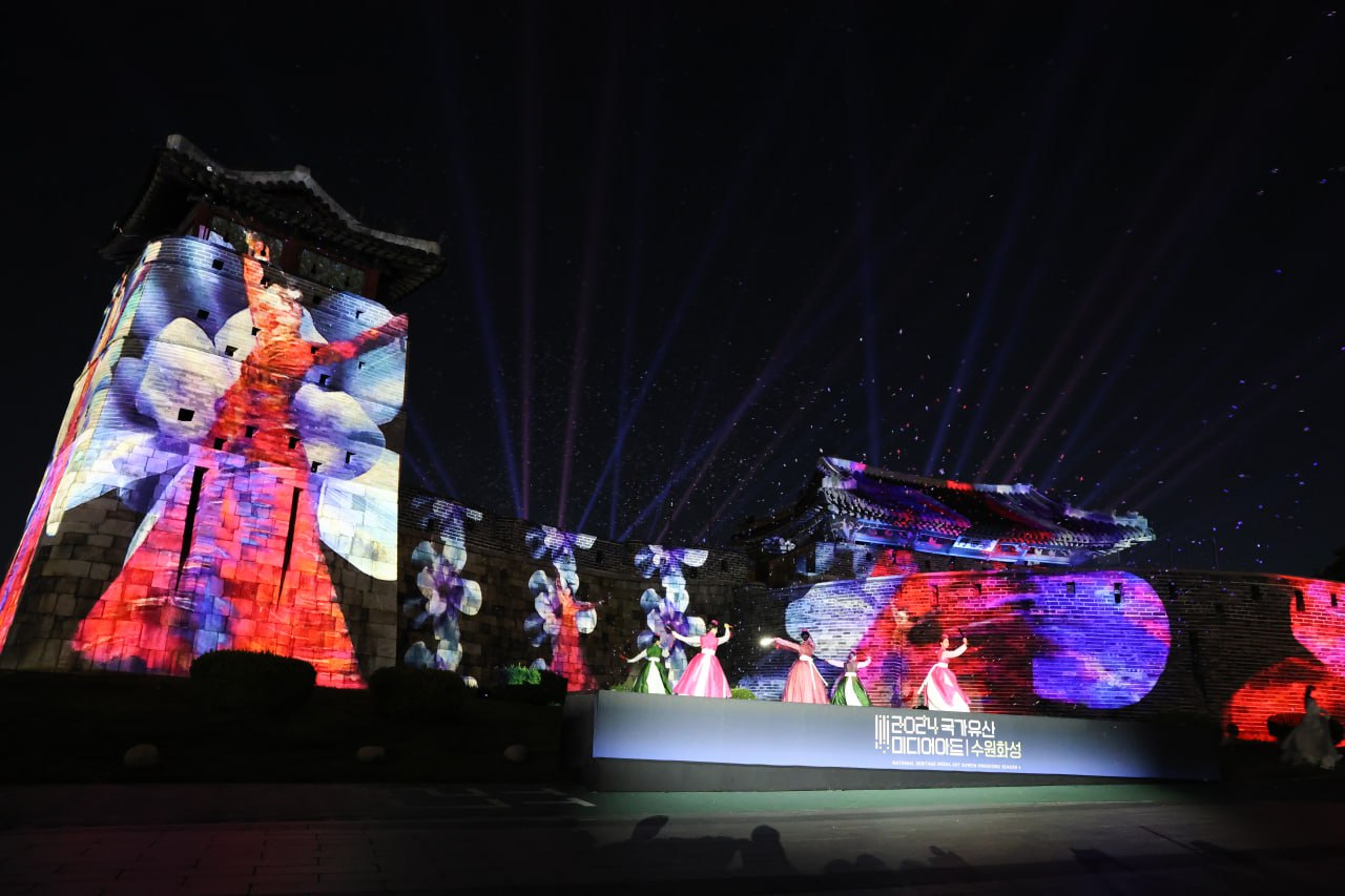 푸른빛 조명 아래, 미디어 아트를 배경으로 춤추는 무용수들의 모습.