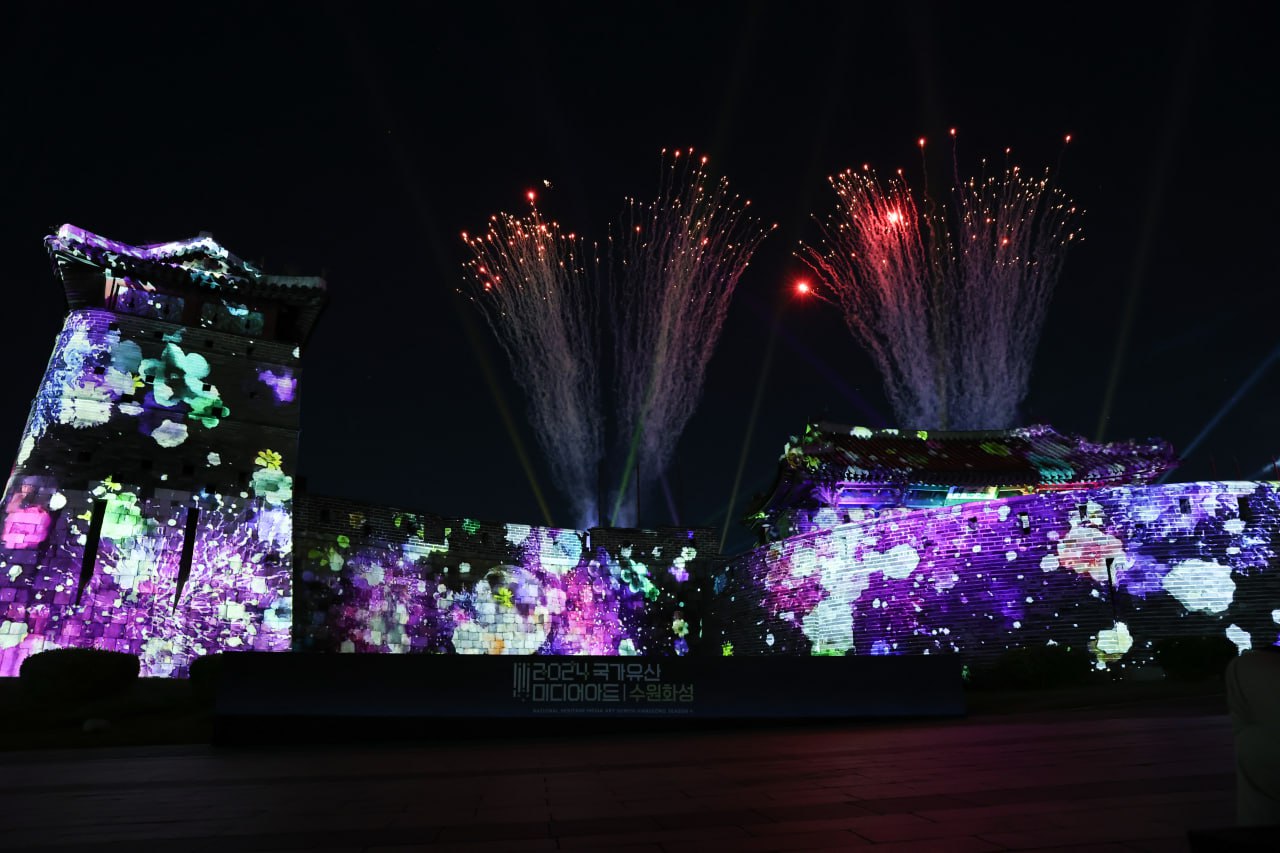 미디어 아트가 상영되는 수원화성 위로 화려한 불꽃놀이가 펼쳐지고 있다.